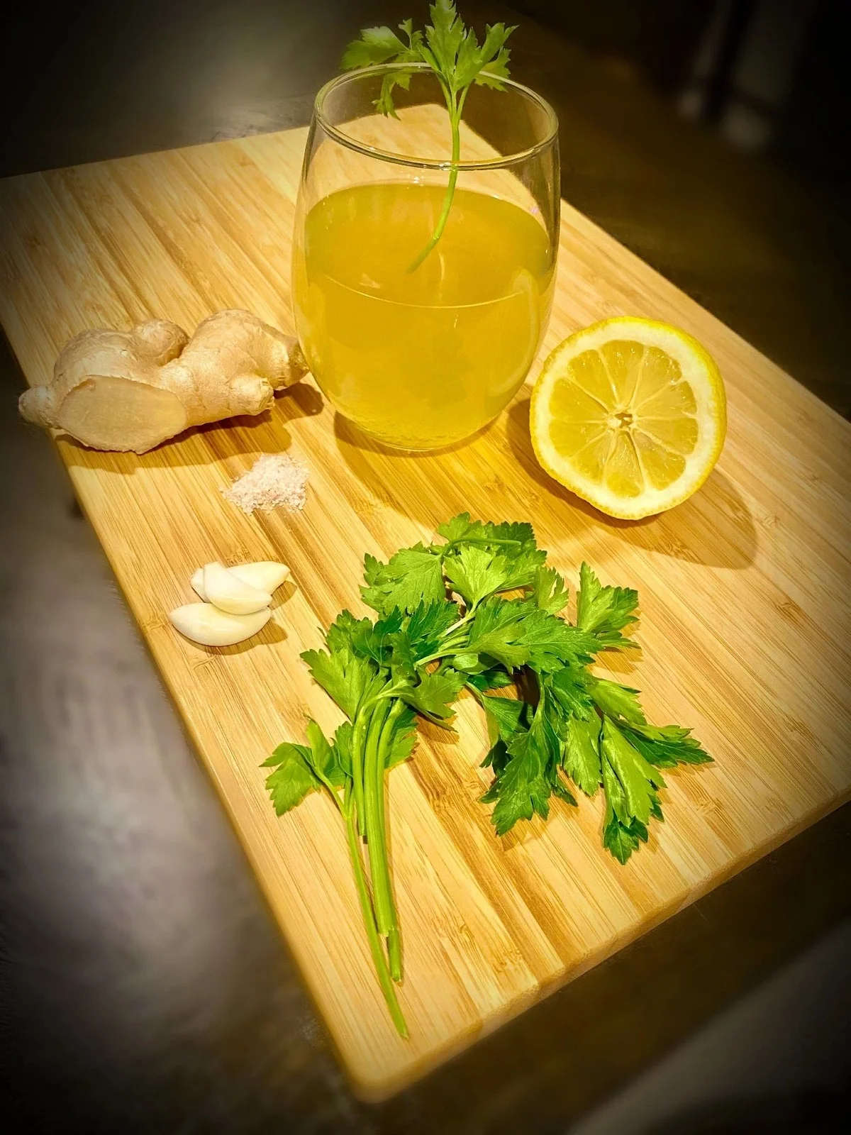 Lemon drink with ginger, garlic and herbs on a cutting board